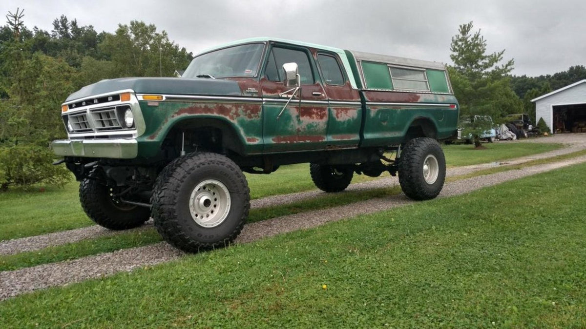 Cody’s green and red 1977 Ford F-250 parked on a gravel drive