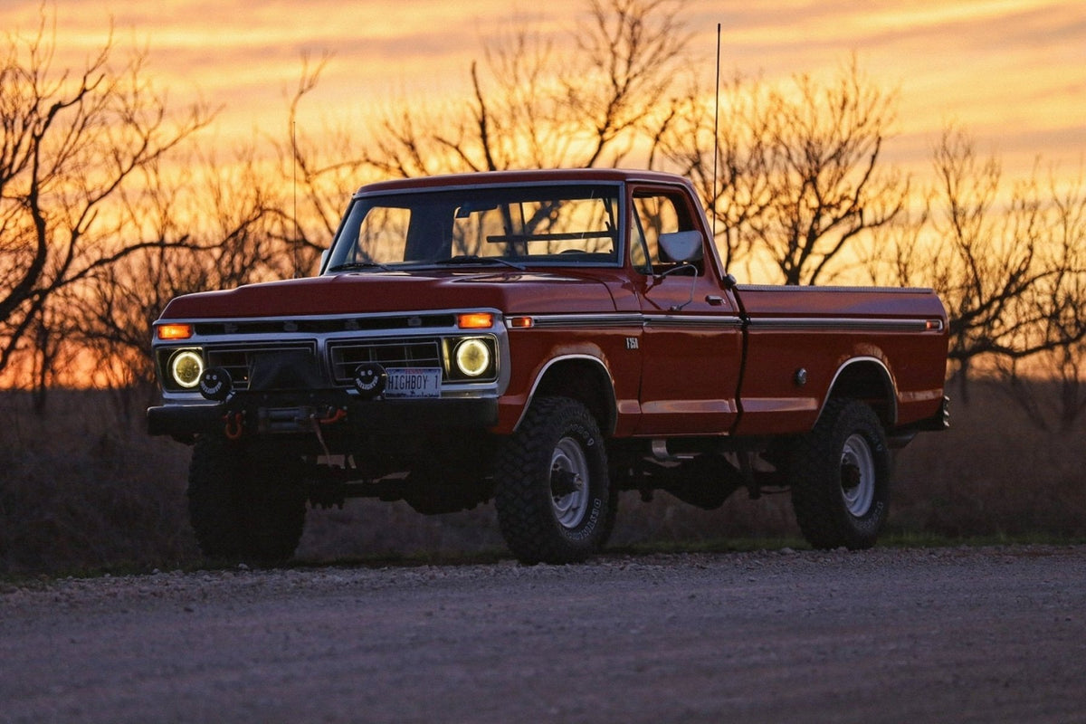 Colt’s red 1976 Highboy with its headlights on at sunset