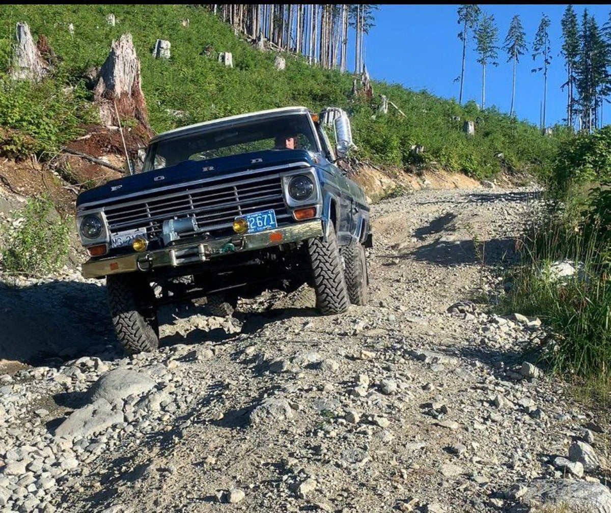 Mark beside his blue 1971 Ford truck in a snowy forest